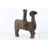 A wooden strainer and pestle, schematically carved in the form of a ram, with incised geometric