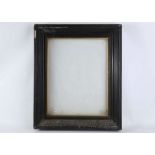 A large ebonised wood and gesso picture frame, with gilt slip, glazed, 66 x 56cm.