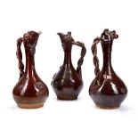 THREE CANAKKALE POTTERY EWERS, OTTOMAN TURKEY, 19th century, glazed in lustrous dark-brown, each