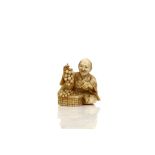 A SMALL IVORY OKIMONO. Meiji period. Depicting a man seated holding up a bunch of grapes in one