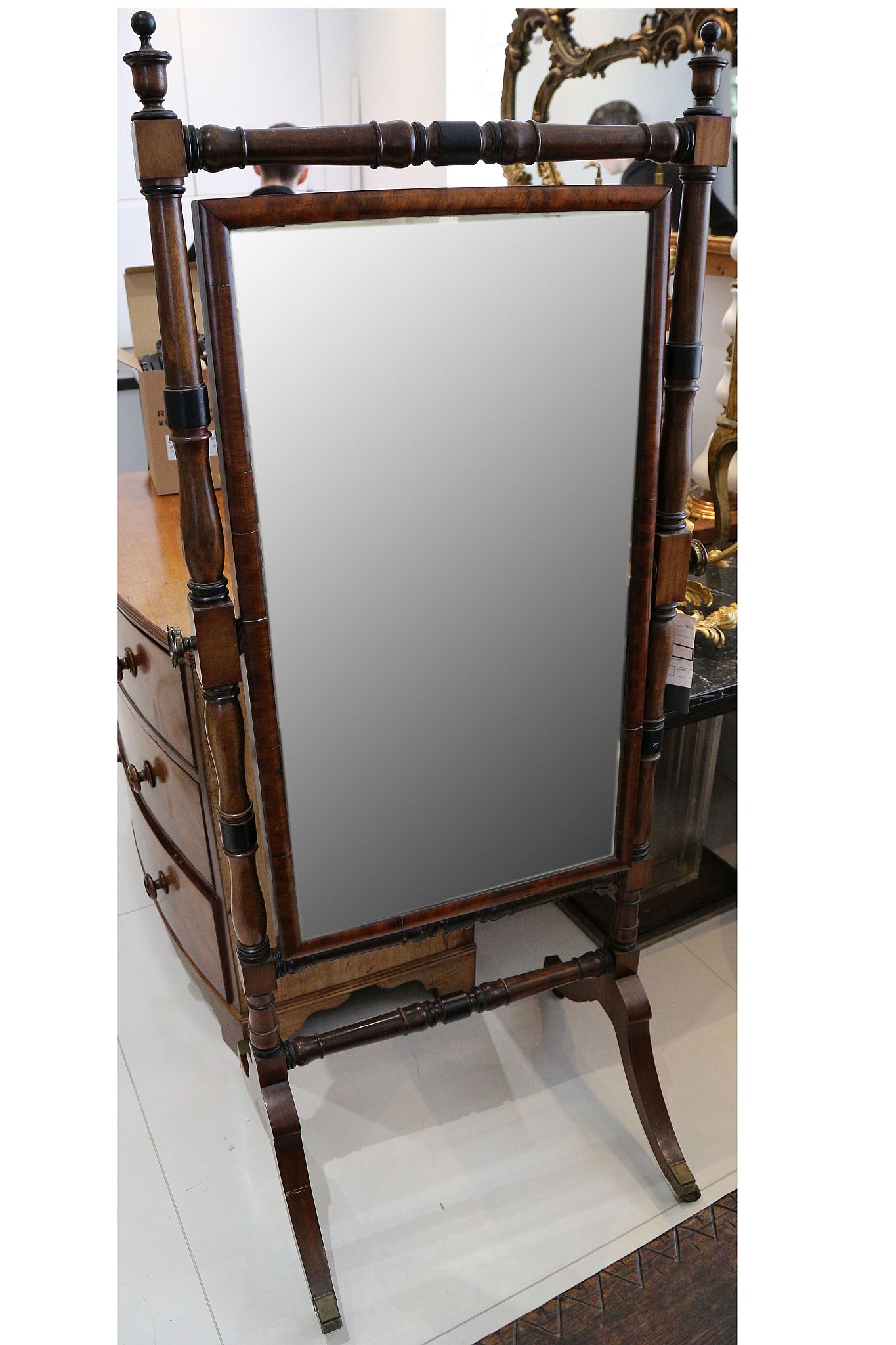 A William IV mahogany cheval mirror c.1835, the turned frame with ebonised sections terminating in