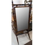 A William IV mahogany cheval mirror c.1835, the turned frame with ebonised sections terminating in