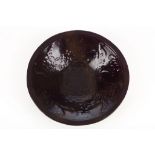 A Japanese aubergine glazed bowl with moulded dragon decoration. 24cm diameter.