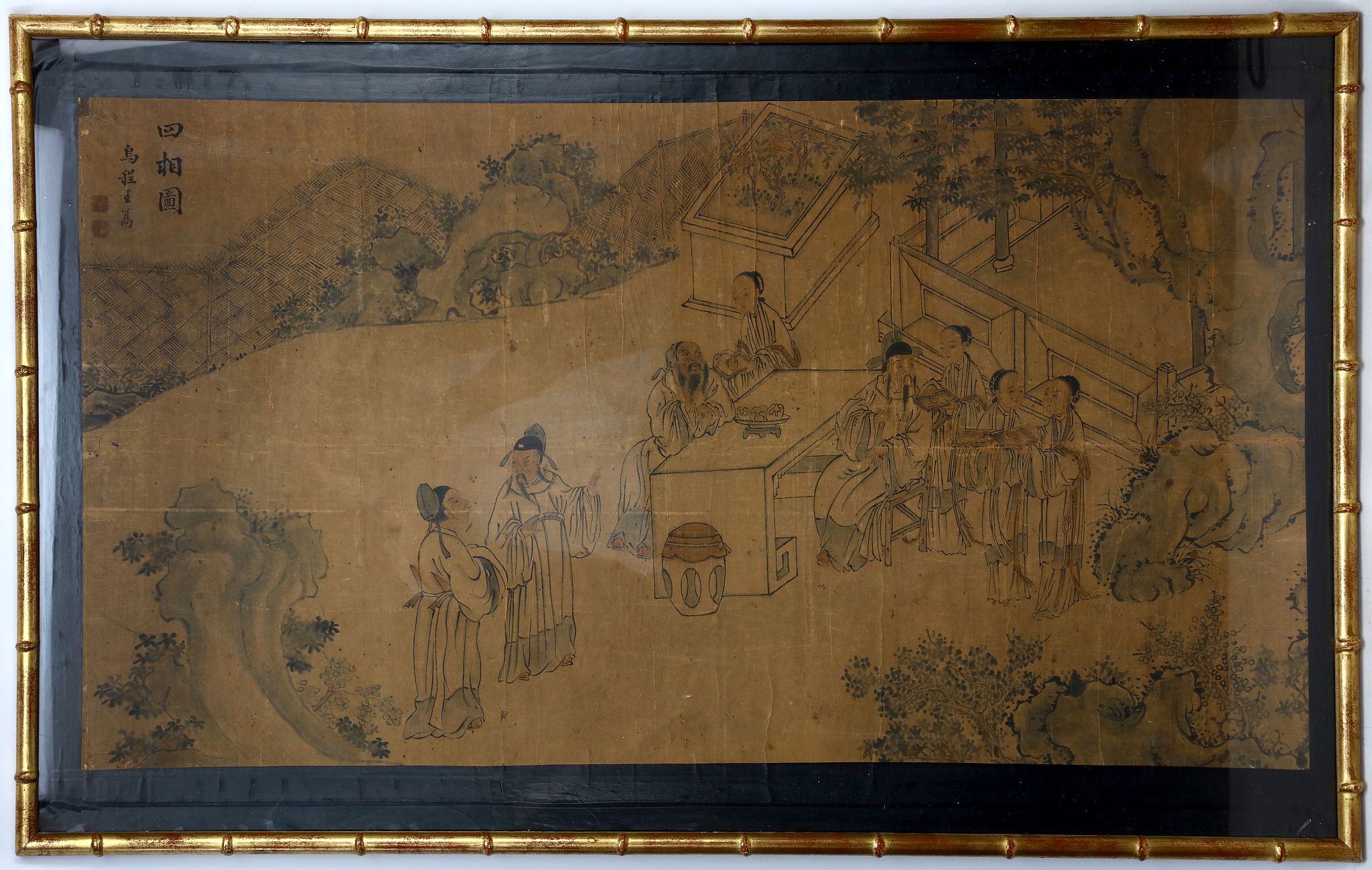 A Chinese ink painting of scholars in a garden with attendants. Framed and glazed. 59 x 114cm.