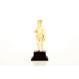 An Indian carved ivory figure of a man standing in a loin cloth with the right hand raised. Wood