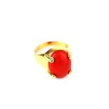 A coral ring, The oval coral corallium rubrum, in a four-claw setting, stamped 750, ring size M