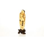 A Chinese ivory carving of Liu Hai, standing with a grinning open mouth and holding a three legged