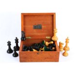 An early 20th century Geo V period boxwood and ebony carved chess set in original mahogany