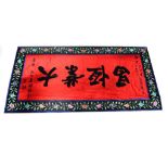 A Chinese red ground calligraphic panel, depicting a well-wishing for a new business venture in