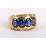 A heavy 18K yellow gold, rub-over set sapphire and diamond set ring. Sapphires: Treated. Size: M