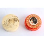 Two Japanese Meiji period circular ivory boxes. One is stained red and carved with animals head to