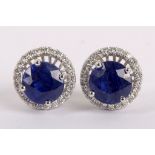 A pair of white gold, sapphire and diamond set 'night & day' ear studs, with detachable halo.