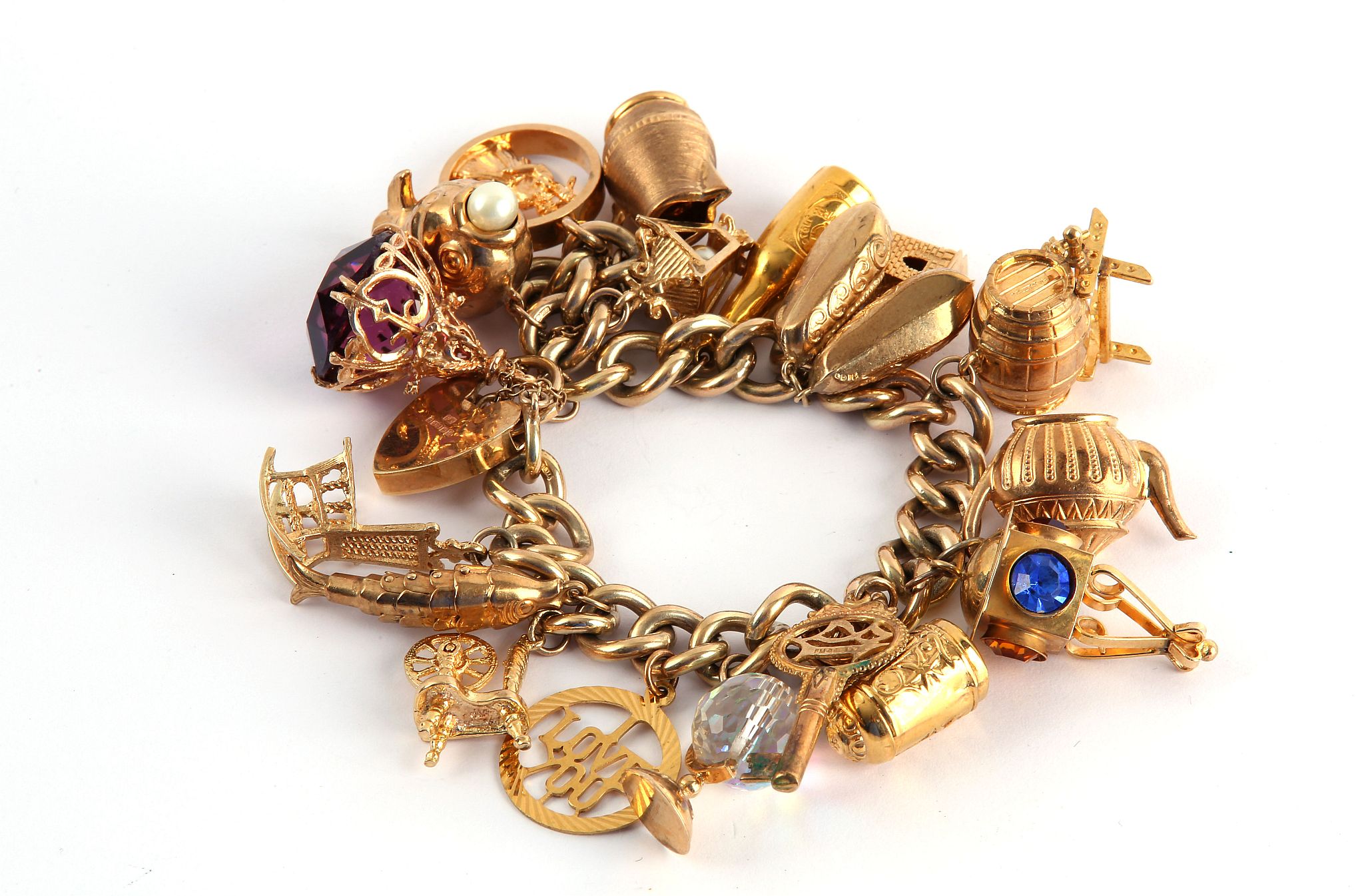 A charm bracelet, The 9 carat gold curb-link bracelet suspending various charms including various