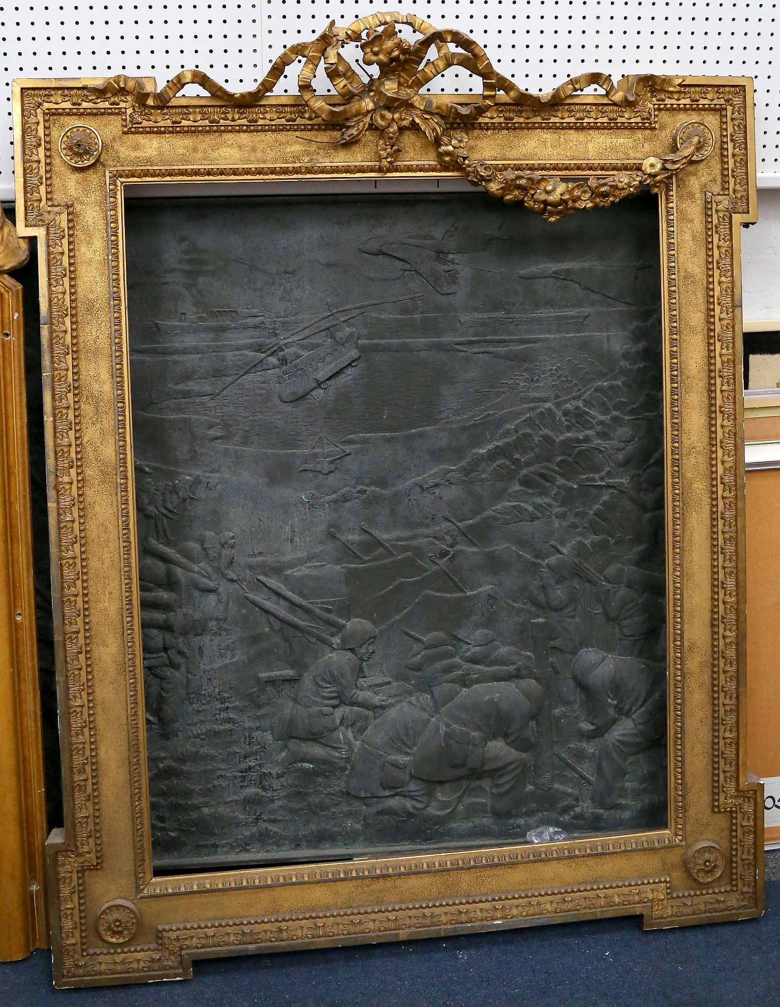 A large gilt mirror/picture frame with ribbon pediment, feature corners, egg and dart moulding