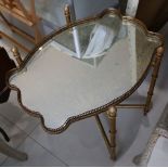 A folding gilded metal faux bamboo table with drop in cartouche form galleried mottled mirror
