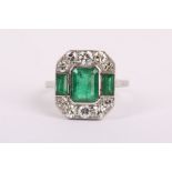An Art Deco design 18k white gold, emerald and diamond set dress ring.