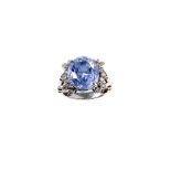 A sapphire and diamond dress ring The oval-cut sapphire, in a four-claw setting, between single-