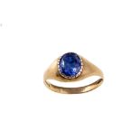 A gold and sapphire ring The collet-set oval-cut s