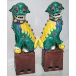 A pair of Chinese famille verte Buddhist lion dogs, early 20th Century, 33cm high.