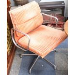 A pair of Charles Eames soft pad swivel chair, manufactured by ICF, with orange upholstery.