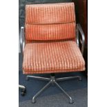 A pair of Charles Eames soft pad swivel chair, manufactured by ICF, with orange upholstery.