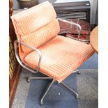 A pair of Charles Eames soft pad swivel chair, manufactured by ICF, with orange upholstery.