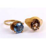 Two gem-set rings, One set with a circular-cut synethic spinel, one with an oval-cut smoky quartz,