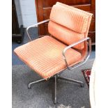 A pair of Charles Eames soft pad swivel chair, manufactured by ICF, with orange upholstery.