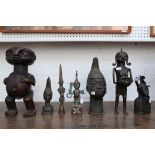 A collection of bronze, mid 20th Century and later, Benin tribal art figures, plus a large carved