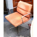 A pair of Charles Eames soft pad swivel chair, manufactured by ICF, with orange upholstery.