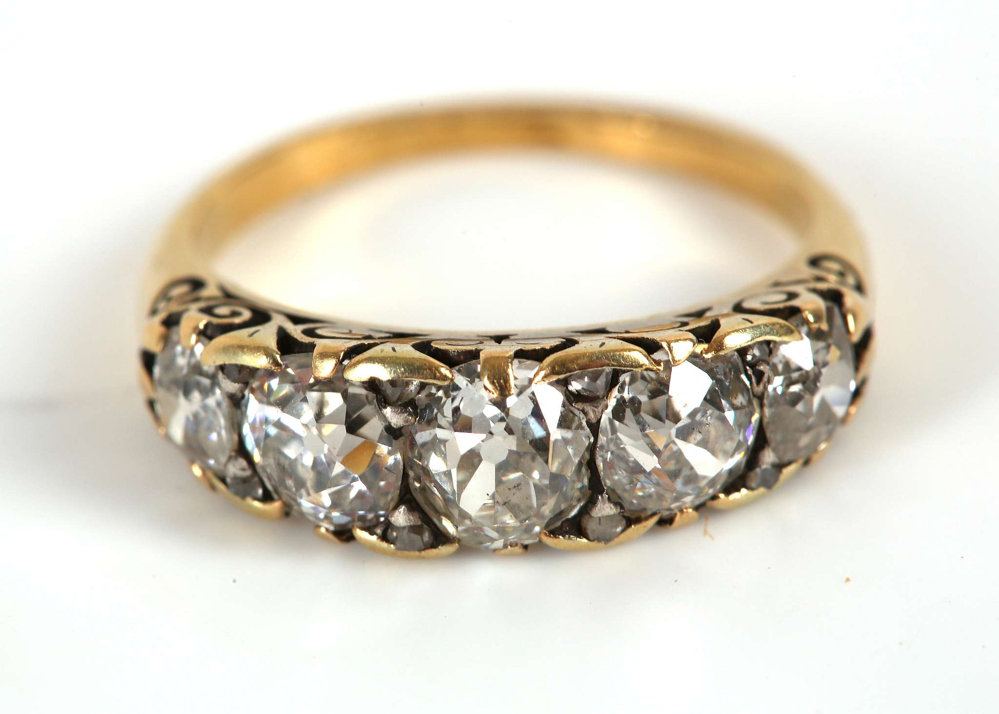 A yellow gold, diamond five stone graduated ring, claw set in a Victorian style open scroll mount.