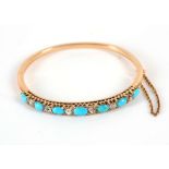 A yellow gold, turquoise and diamond hinged bangle claw set in an open work mount.