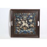 An early 20th Century Chinese embroidered silk panel with bird, fitted within a square tray frame.