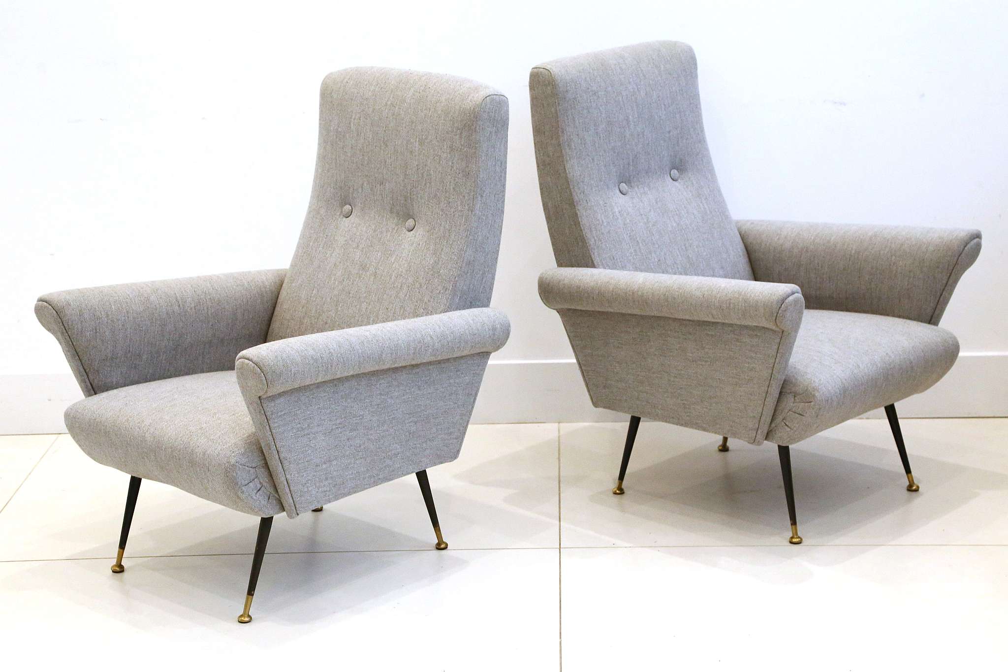 A PAIR OF 1950s ITALIAN ARMCHAIRS, newly upholstered in grey, on black enameled legs, (70cm max wide
