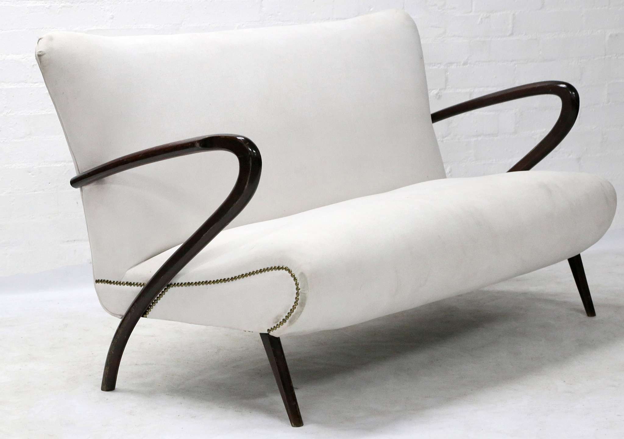 A 1950s ITALIAN TWO SEATER SOFA, designed by Paolo Buffa, with dark stained beech sculptural arms