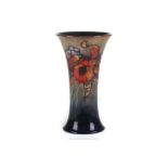 A WILLIAM MOORCROFT POTTERY VASE OF OVOID FROM, tube-lined with orchids and spring flowers