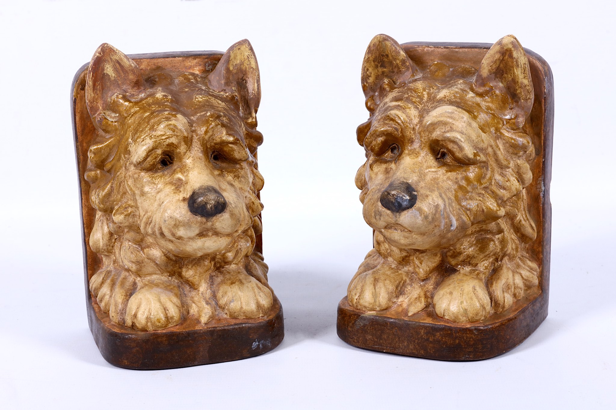 Compton pottery, a pair of unusual book-ends modelled as dogs, in light brown semi-matt glazes, c.