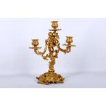 A bright gilded 19th Century 3 branch rococo candelabra with cherub below central branch,