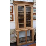 An early 20th Century light oak bookcase, enclosed by 4 glazed doors on plinth foot.