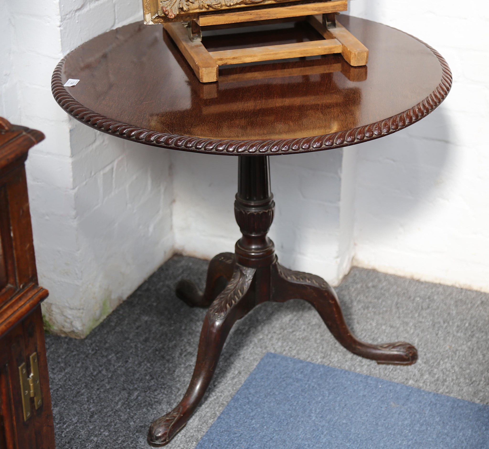 A mahogany tripod table in George II style, the circular top with turned support on triform cabriole