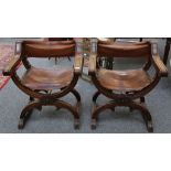 A pair of 18th Century style, Italian walnut X frame elbow chairs with tan leather backs and seats.
