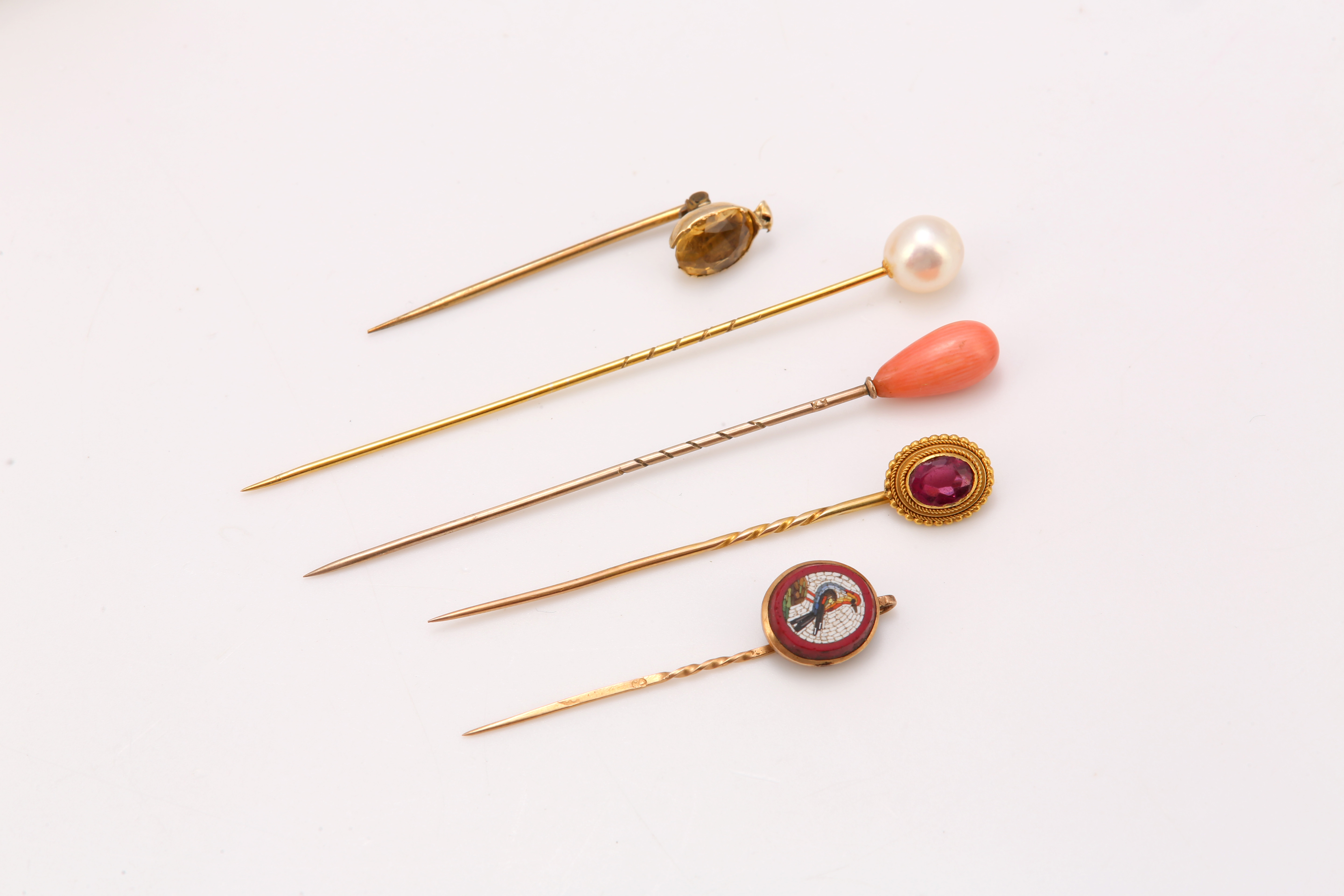 A group of five stickpins, with coral, cultured pearl, citrine, pink paste or micromosaic terminals,