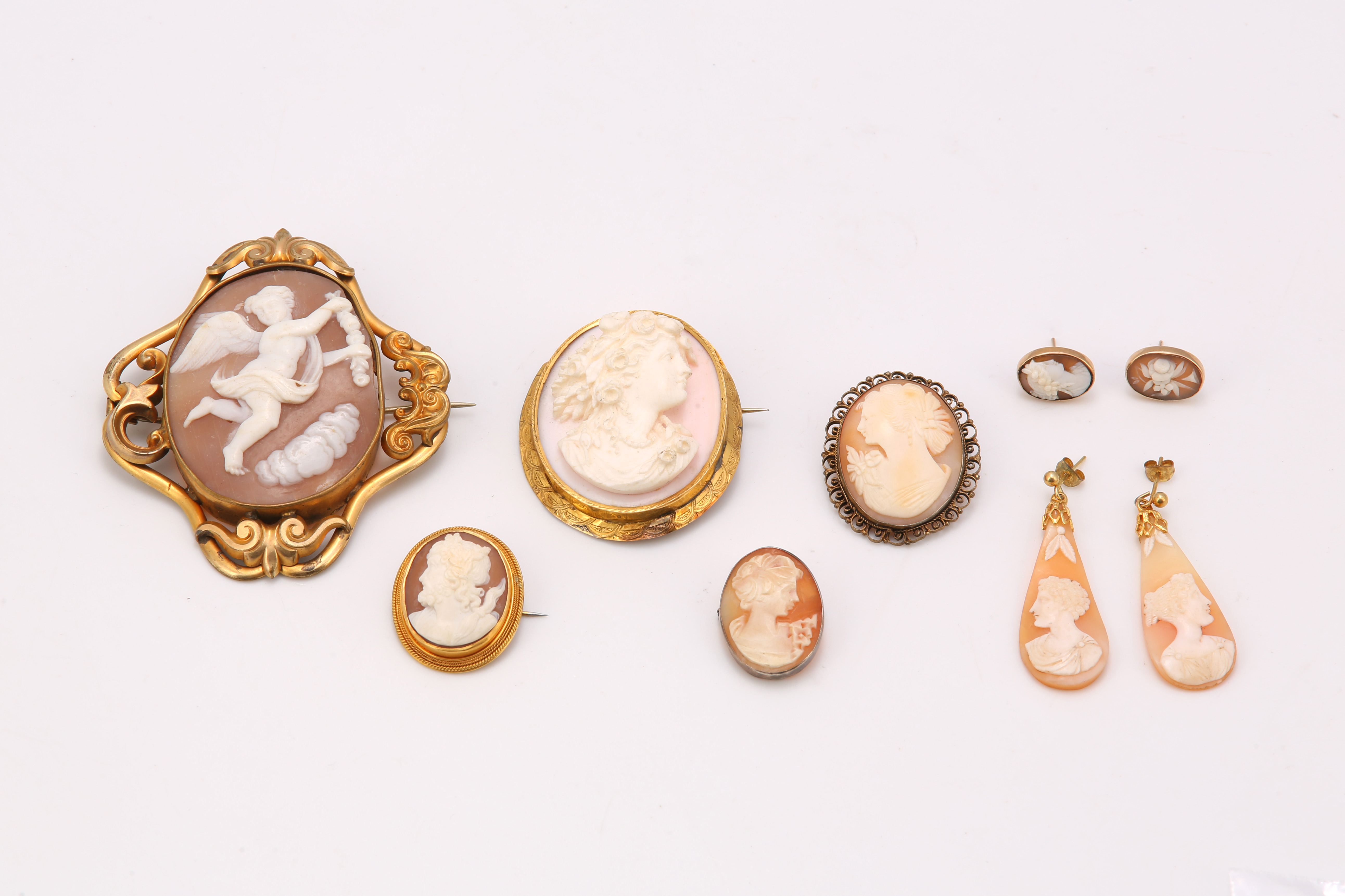 A collection of shell cameo jewellery, including five brooches and two pairs of earrings (5)