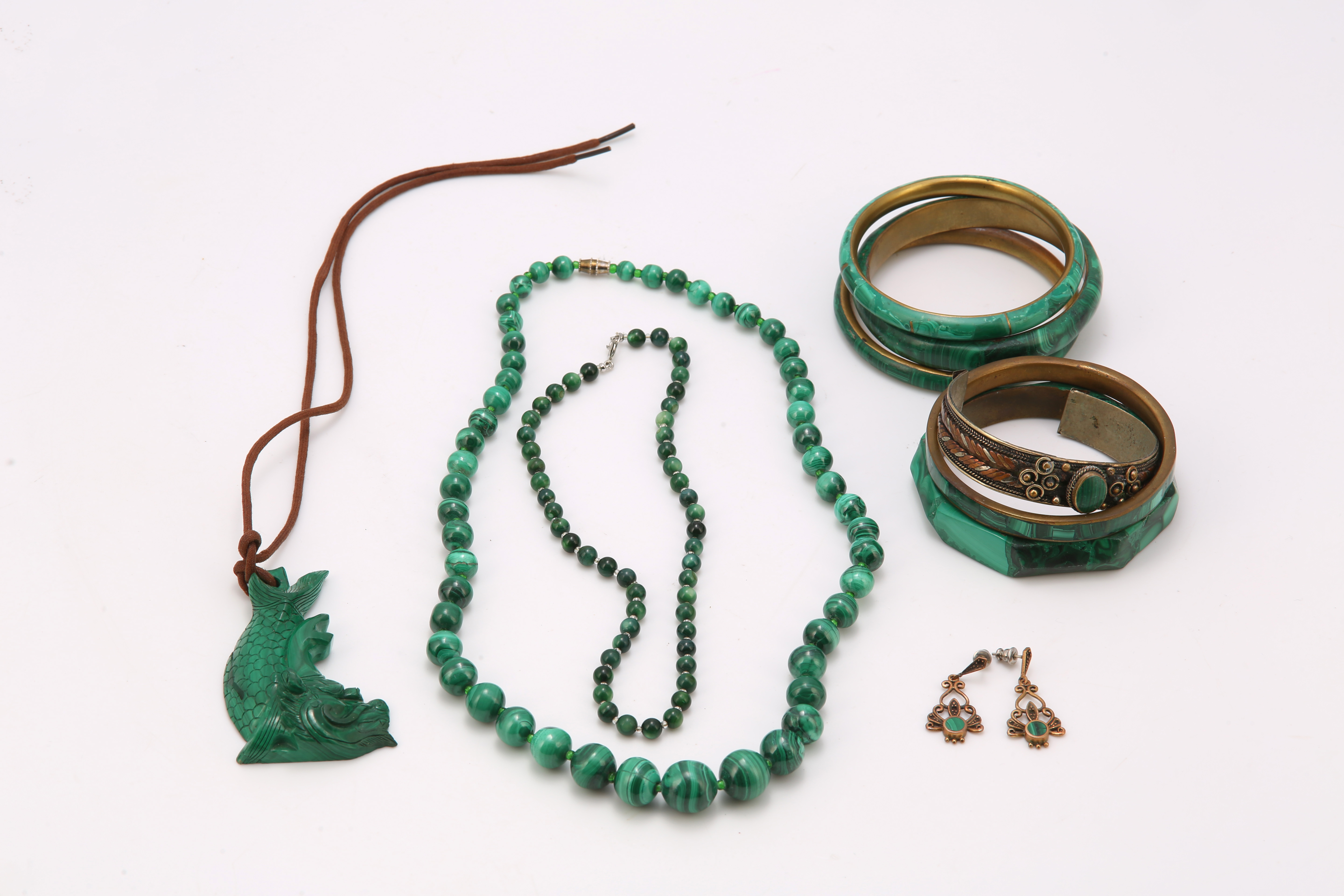 A group of malachite jewellery, including six bangles, two bead necklaces, a carved pendant and a