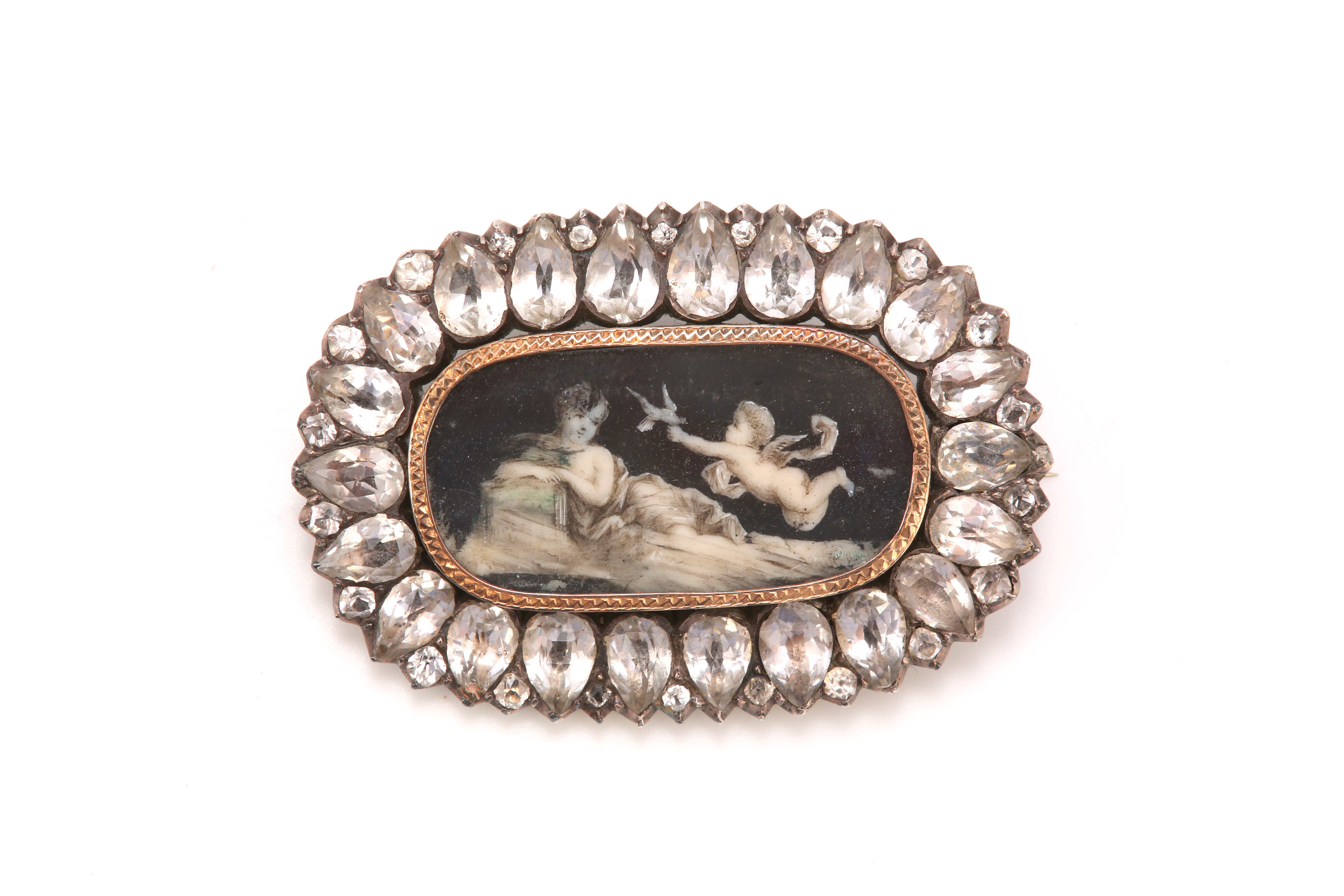 A paste mourning brooch, circa 1875, The oval ivory plaque depicting a woman reclining with a cherub