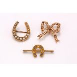 Three brooches, including a half-pearl set bow brooch and half-pearl set horseshoe brooch and a