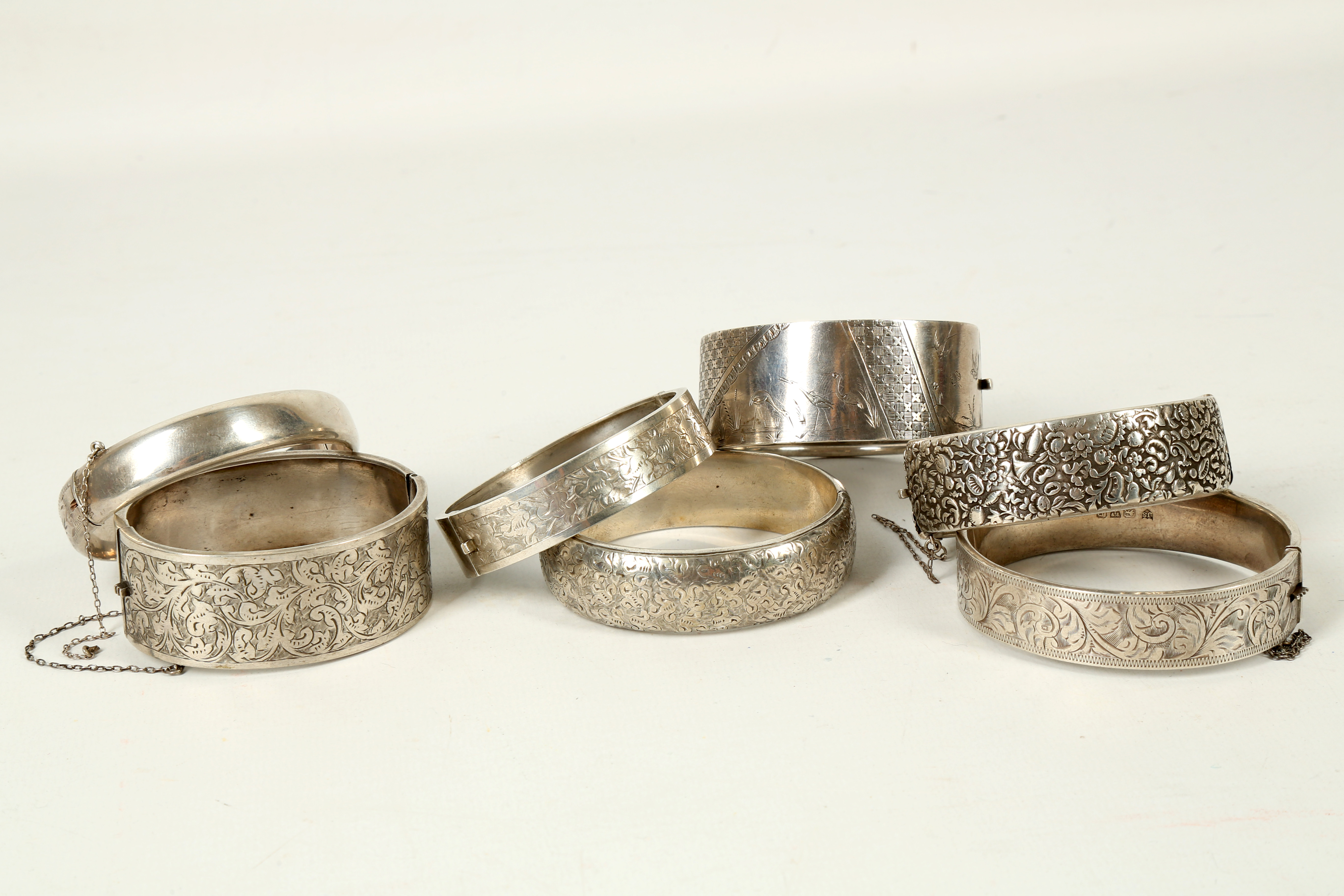Two Victorian style engraved silver hinged bangles, an Indian white metal bangle and four further
