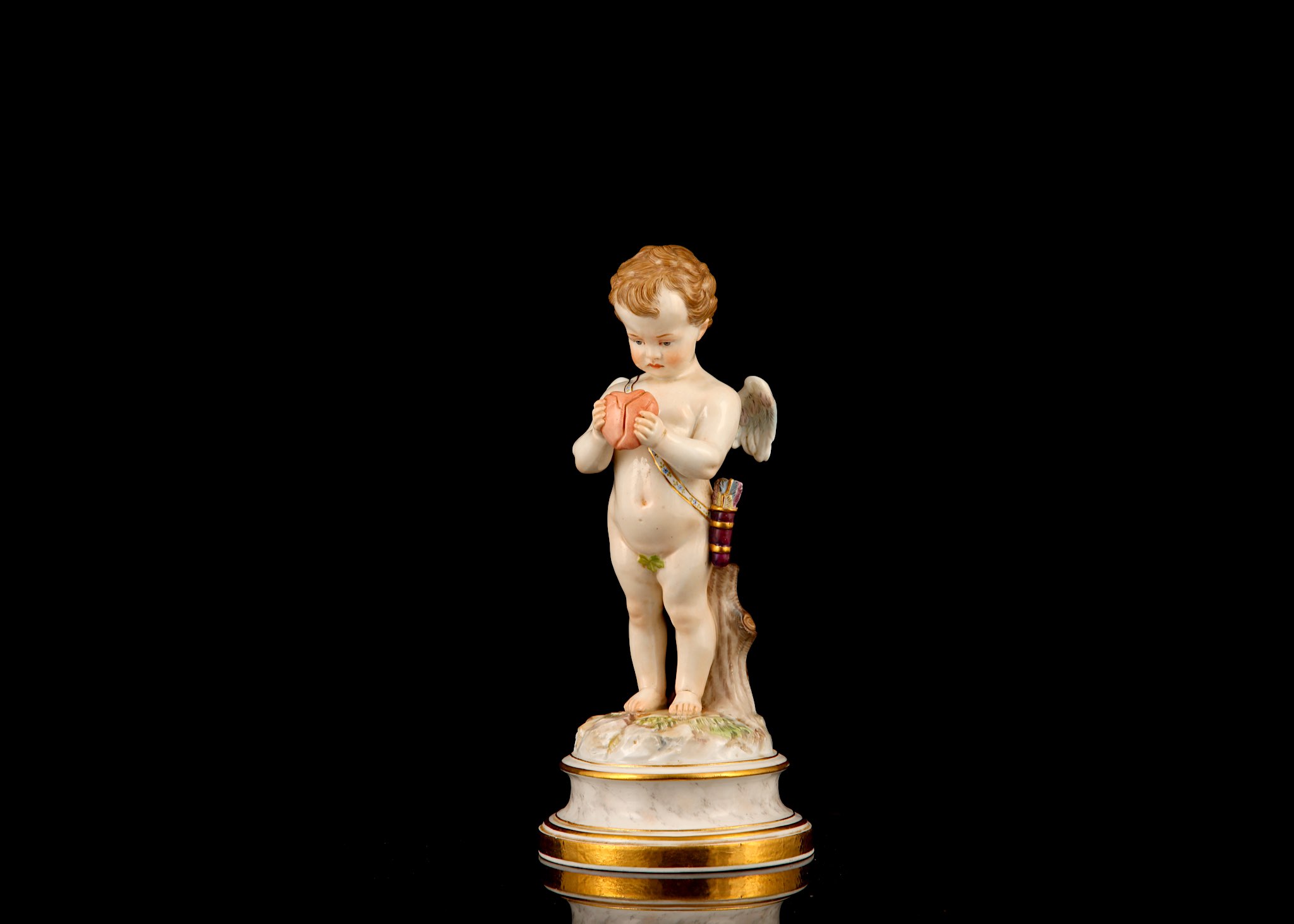 A MEISSEN PORCELAIN FIGURE OF CUPID HOLDING A BROKEN HEART, late 19th century, modelled by