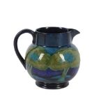 A WILLIAM MOORCROFT 'MOONLIT BLUE' POTTERY JUG, circa 1925, of globular form with an applied