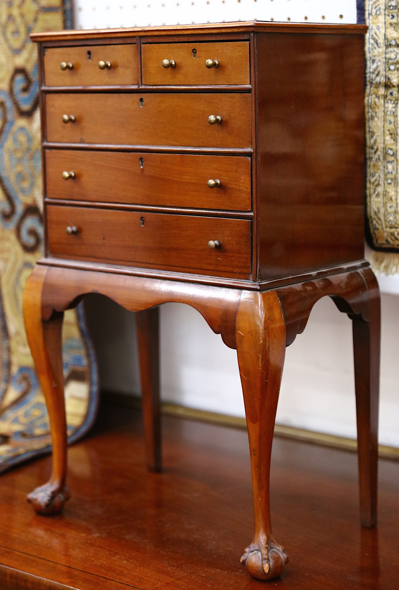 A 19th Century miniature chest of two short and three long drawers, raised on a cabriole legged